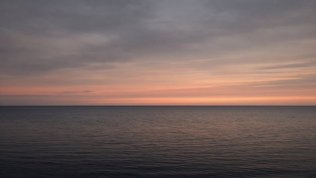 A dusk seascape with a clean, level horizon across the frame